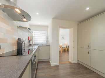 fitted kitchen with integrated appliances, and a sitting room opening out on to a