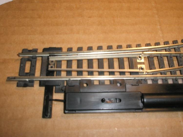 This can t be done with the switches that have the moveable rails riveted. The freed rail will have to be raised upward or the tab pushed downward under the rail to become loose.