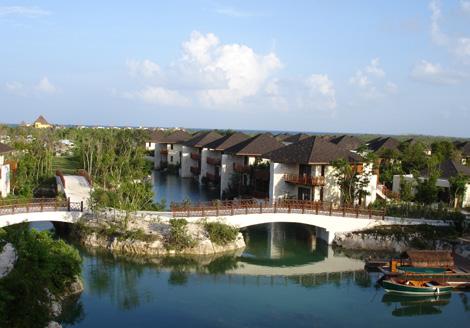 View of the Fairmont Hotel villas and boat for displacement of customers through the network of channels Mayakoba.