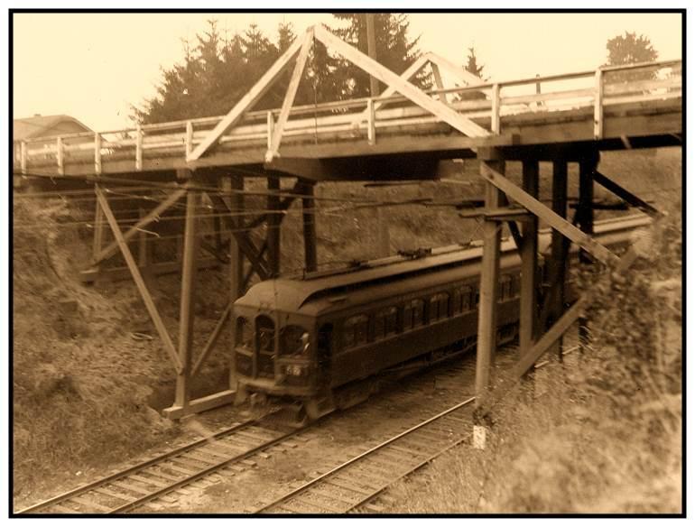 An Oregon Electric train passes under an overpass at