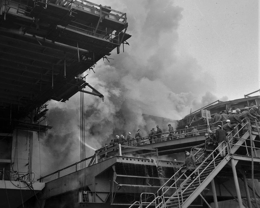trapped four decks below. Lieutenant Hamilton dispatched Fr. Motti to get a rope and a charged hose line to assist them in the rescue. The metal on the decks was hot.