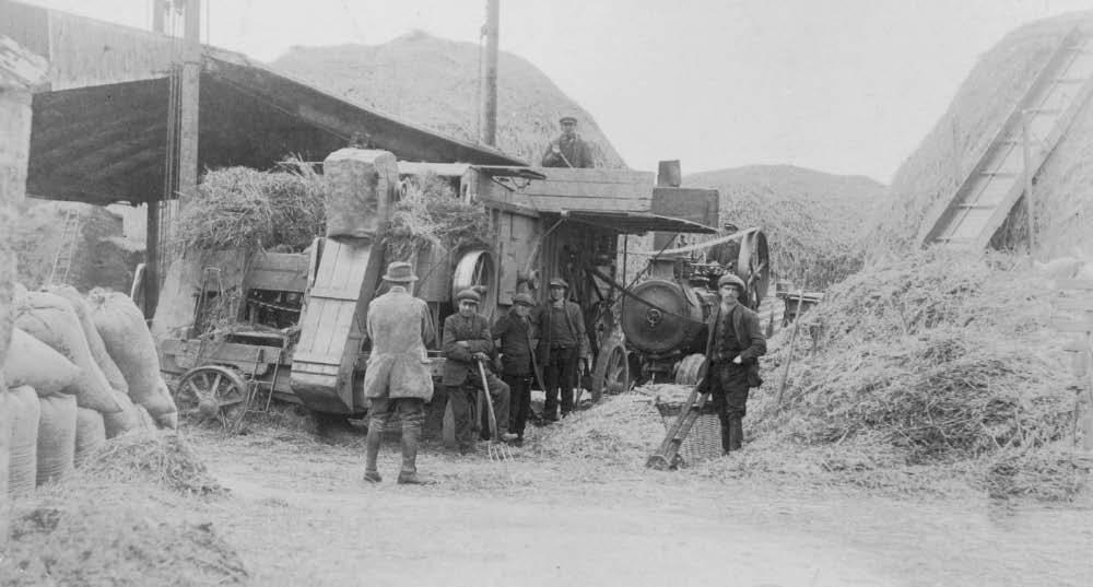 A Gibbons Robey steam engine threshing at Manor Farm Sutton (Fred Holmes ) May 1916: back to camera Mr Matchet (gamekeeper), Billy Brown with wheels on right, Charlie Clark on drum, Bob Gilbert (with