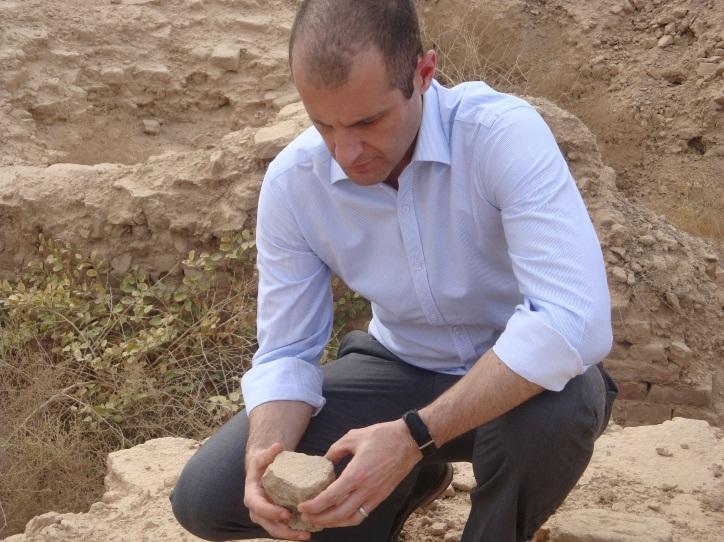 [Photo Caption: Dr Benjamin Isakhan inspects a cuneiform tablet found lying on the ground at the ancient city of Babylon, the fragile tablet is left exposed to the elements.