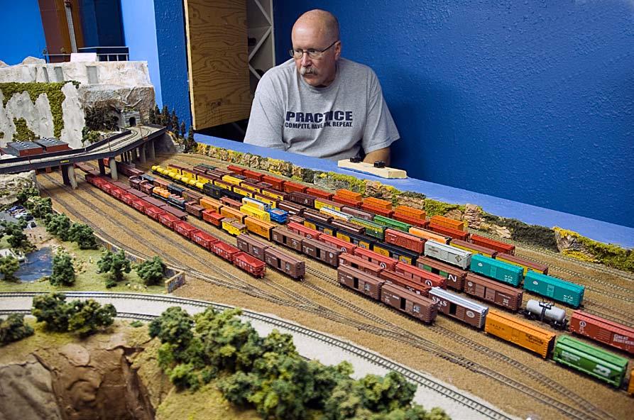 Scenery Focus of N Scale Layout David Bol, seated on a viewing platform at one end of his layout, surveys a freight yard on his layout. David controls his trains using Digitrax DCC.