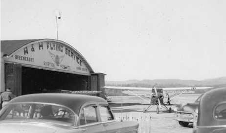 A series of 3 undated photos (circa 1950s?) of 3 DC-3s in front of the Asheville Hendersonville Airport terminal, and other aircraft in front of the Skyline Airways hangar (courtesy of Mike Whitt).