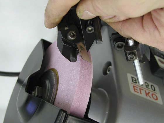 Trimming knife edge sharpening - By moving from the right to the left, move the knife against the wheel.