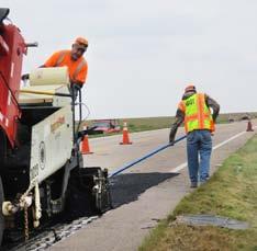 At left, David Piedra, Equipment Operator from Dighton, drives the asphalt zipper while