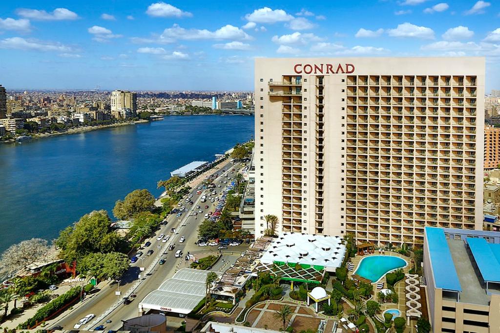 ACCOMMODATION CAIRO CONRAD CAIRO HOTEL Rising above the Nile River, the four star Conrad Cairo is located in the downtown area of the city along the Corniche, conveniently close to museums, shops and