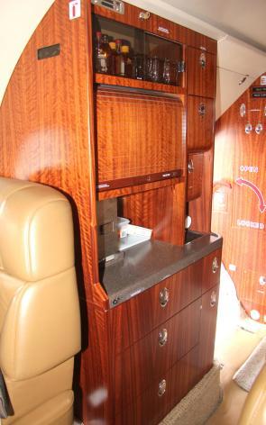 INTERIOR Eight passenger interior with five individual fully articulating chairs with drop down inboard arms arranged in a forward club, aft three place divan with foldout table-center seat cushion,