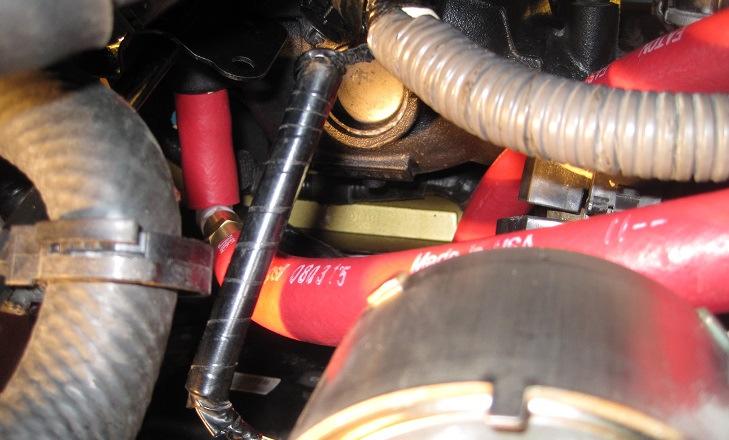 Work the hose up to the intake manifold by going over the engine oil cooler and filter housing, underneath the starter wires and harness, and push/twist it firmly onto the port.