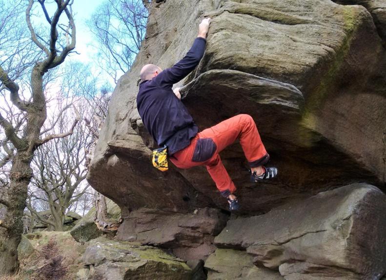 . Make a difficult reach to the good rail on the lip and follow it left to the front of the buttress before a hard move up to good holds, (6a from stand).