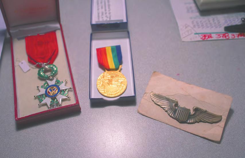 Three of Crews World War II medals the French Legion of Honor, a D-Day commemorative medal and U.S. Army Air Forces wings lie on his bedroom desk. (Above) Crews during his military service.