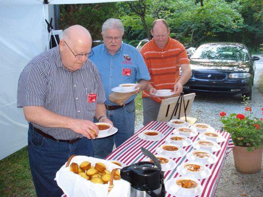 Page 4 " " Harold Funkhouser & Mike Smith help themselves to Hobo Vegetable Soup with cornbread muffin, while Scott