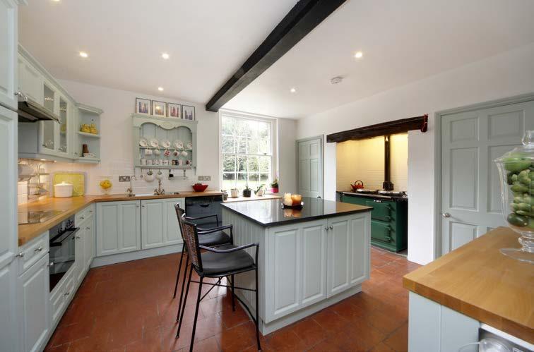 The kitchen has a two oven gas fired Aga and range of cupboards with built-in ceramic hob and electric oven. The central island has a polished granite worktop.