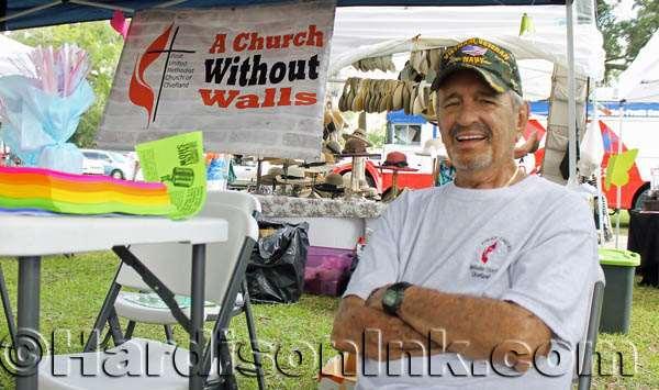 , a member of the First United Methodist Church s congregation, greets visitors at the church s tent.