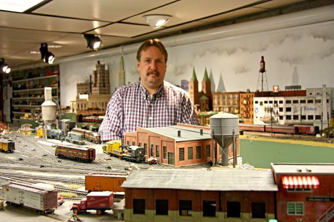 Kevin in front of Newark, NJ; station to rear left Greenville yard with engine facility just in front of him NEB&W model railroad.