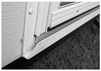Lower and install bottom of screen door into