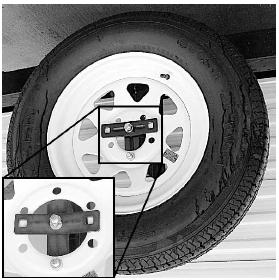 Remove the cotter key from the pin holding the tire carrier in place. 2. Remove the pin and extend the tire carrier away from the trailer. 3.
