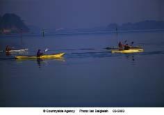 Canoeing in Poole Harbour. Agreement and harmony with the landscape for co-ordination in signage and interpretation between different information providers e.g. World Heritage Site, Tourism, Countryside Service, private, advertising.