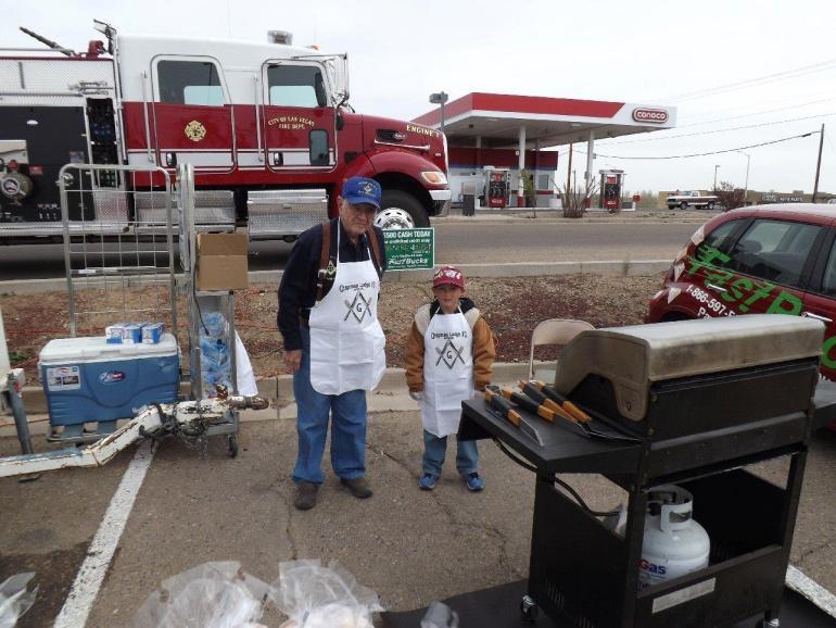 Outside the Lodge WM Clyde Turner is a Mason of Many Aprons, as he and Johnathan Silva prepare to grill burgers and hotdogs for the Children s Miracle Network this May.