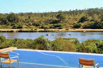 A large rim-flow swimming pool with in-pool martini seat overlooks the Crocodile River and Kruger.