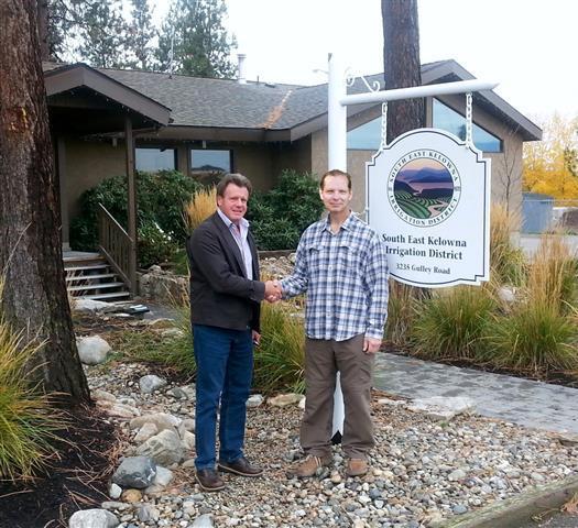 Toby Pike, General Manager of the South East Kelowna Irrigation District (SEKID) and FOSS Director Ken Wiklund shake hands after signing a Trail Use Agreement that will see FOSS manage the trails