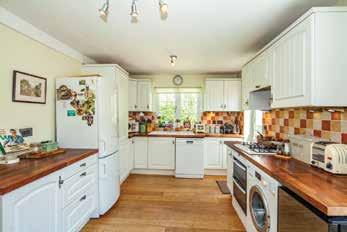 The front door opens into a central Reception Hall, and on to the L-Shaped Kitchen/Breakfast Room with side door, and Sitting Room with wood burning stove, large picture window overlooking the garden