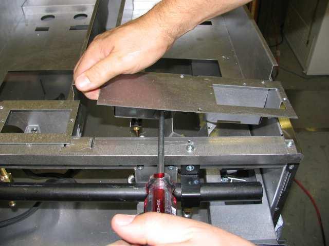 Lower the box into position and access the right screw of the orifice bracket from below the manifold.
