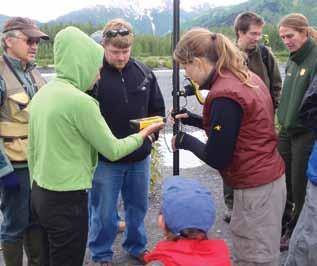A campsite monitoring team discussing methods at a training session. Figure 5. Alaska Regional Office database programmer Greg Daniels collects GPS data and records campsite attributes in the field.