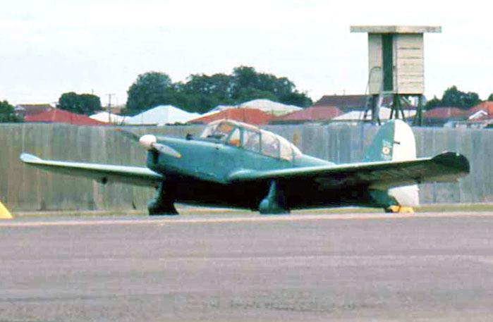 G-AOMF S flat green paint scheme can be seen in this telephoto shot at the old Brisbane Airport on 4 May 1969. The Prentice is parked close to the fence of the Eagle Farm horse race course.
