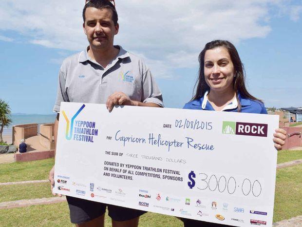 Yeppoon Triathlon Festival organiser Glenn Skinner with RACQ Capricorn Helicopter Rescue PR and Community Coordinator Kirsty Wooler with a cheque for $3,000 from money raised by the event which went