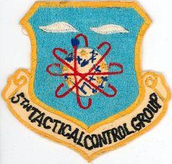 5 th Tactical Control Group emblem Light blue, in nobril a sphere bendwise argent grid lined azure surmounted by a stylized aircraft bend sinisterwise of the like and five mullets or, the sphere