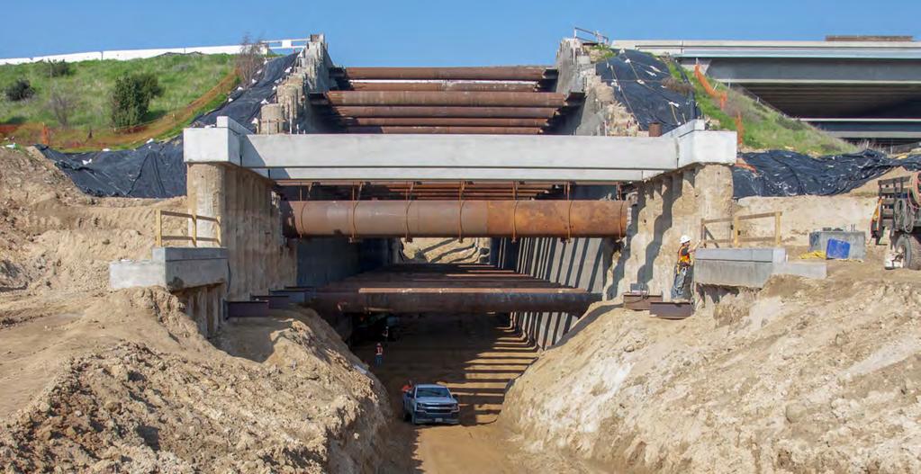 As crews put the finishing touches on the walls inside the undercrossing, others excavate the area outside where the trains will come back to grade.