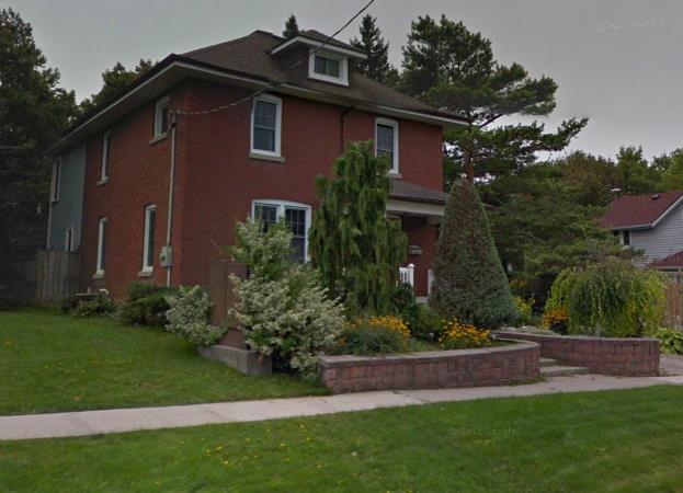 - 2-storey red brick house on concrete foundation. - Hip roof with small dormer window facing the street. - 2-bay façade with side entrance. William M.