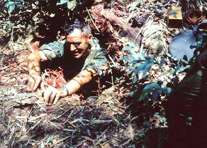 Arthur Anderer emerging from VC tunnel after placing explosive charge. Red coloring on the entrance rib could be from residue from red smoke grenade.